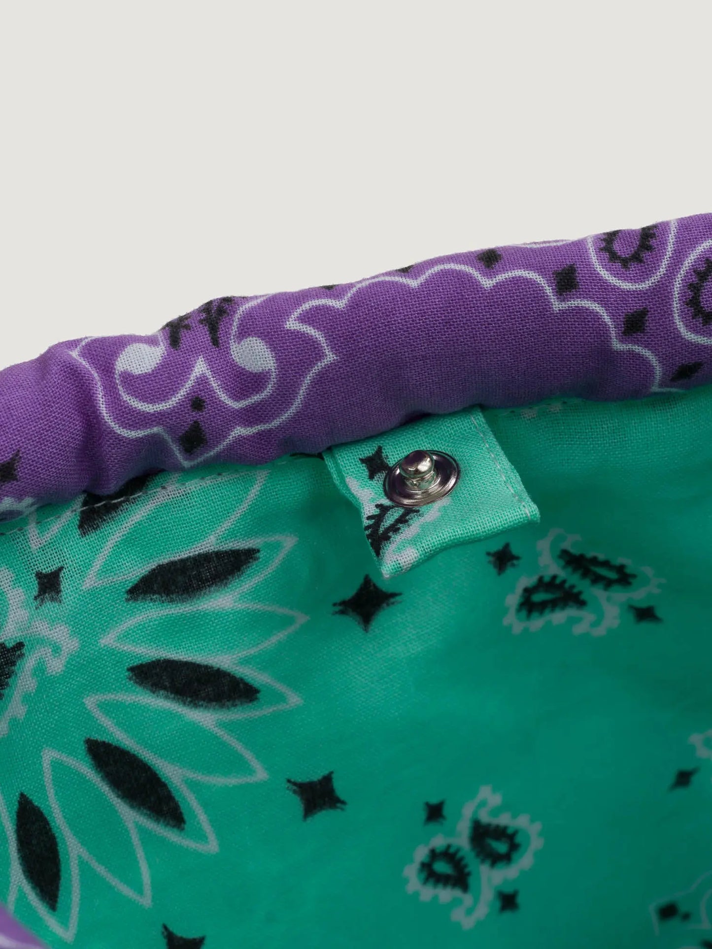 Purple and mint bandana bucket bag with adjustable strap, by brand Call it by your name, close-up on closure