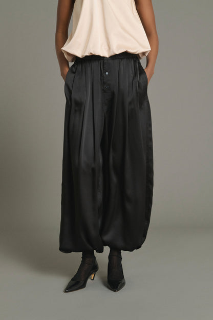 Model wearing the Soeur Leopold black silk satin balloon trousers, front view from the waist down