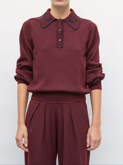 Model wearing the Molli Amour amaranth knit polo shirt with midnight hand embroidery and matching amaranth knit pants