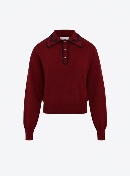 Flat-lay view of the Molli Amour amaranth knit polo shirt with midnight blanket-stitch embroidery on the collar and placket