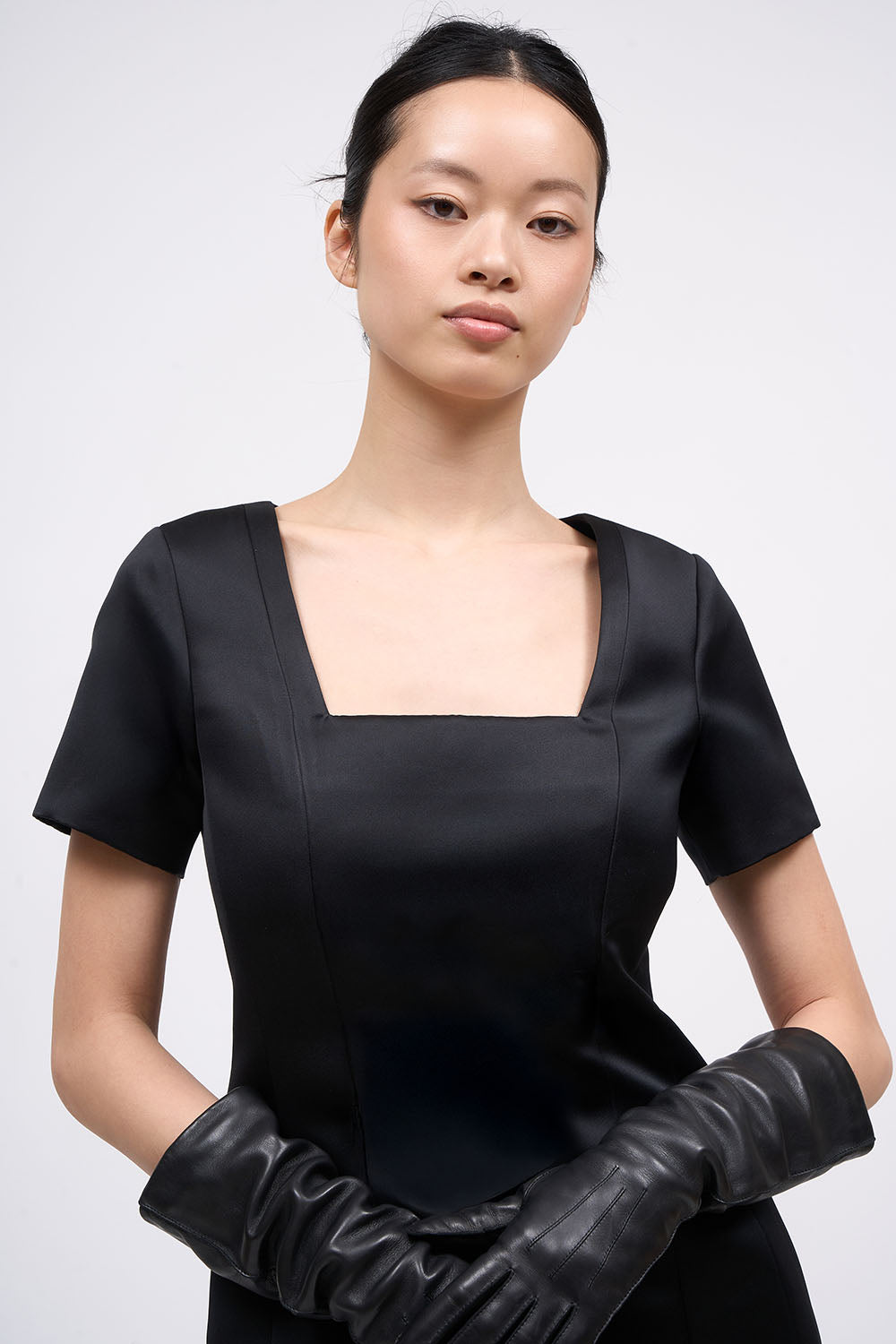 Close-up of the square neckline on the Paul & Joe Venus black satin dress