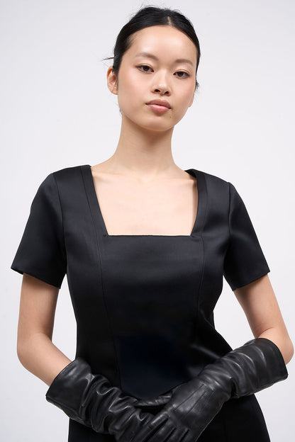 Close-up of the square neckline on the Paul & Joe Venus black satin dress