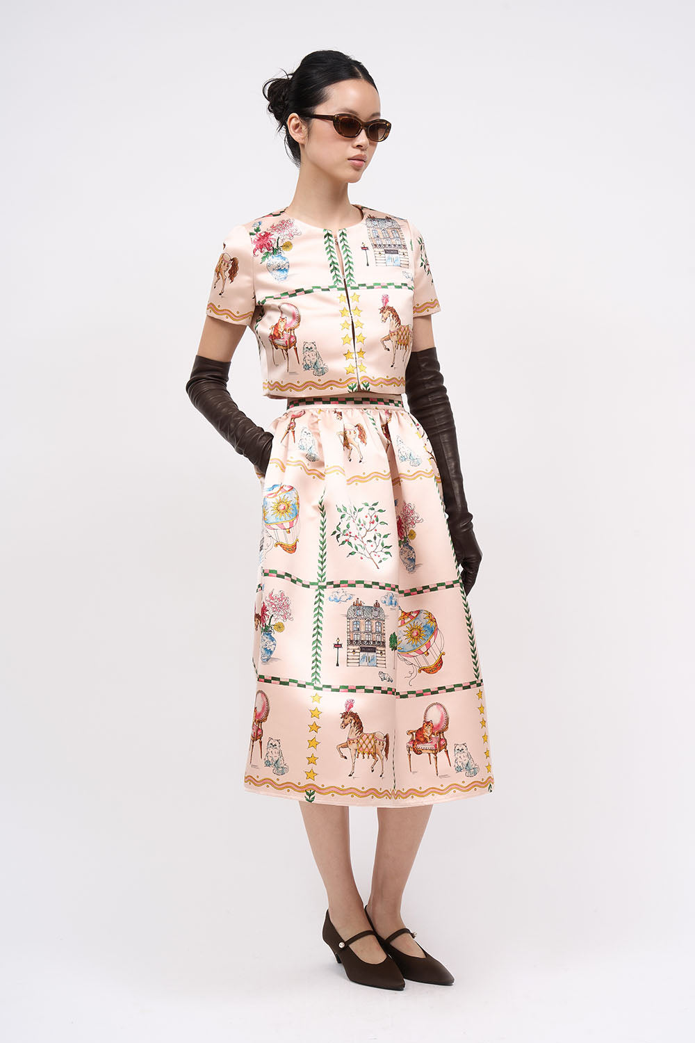 Front view of the Paul & Joe Voyage light pink printed duchess satin short jacket, worn with the matching skirt