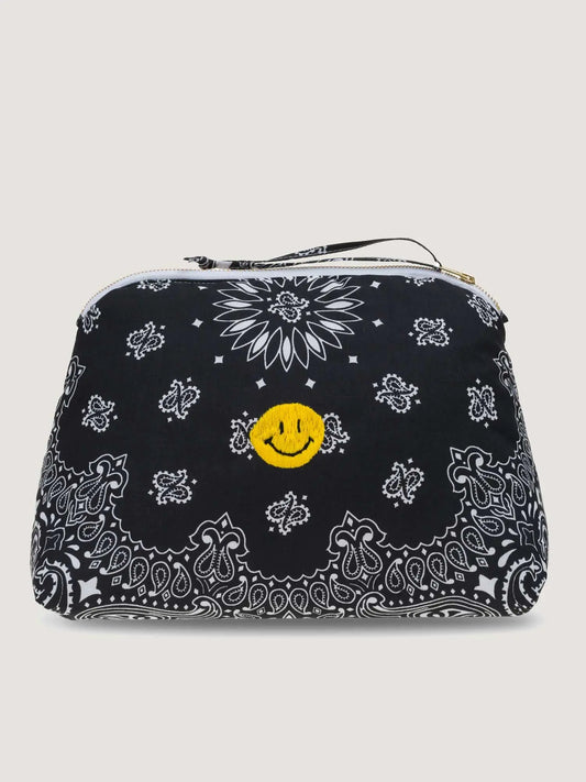 A large cosmetic pouch with a bandana print featuring a yellow smiley face design in the center, predominantly in black and white colors.