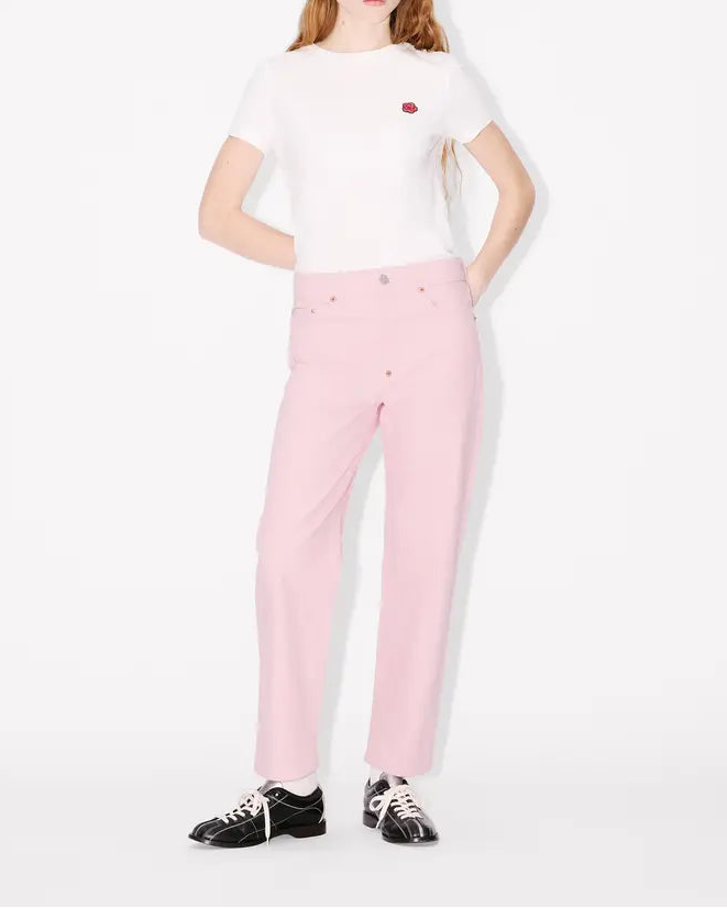 Person wearing a white t-shirt and pink jeans straight leg japanese denim on a white background