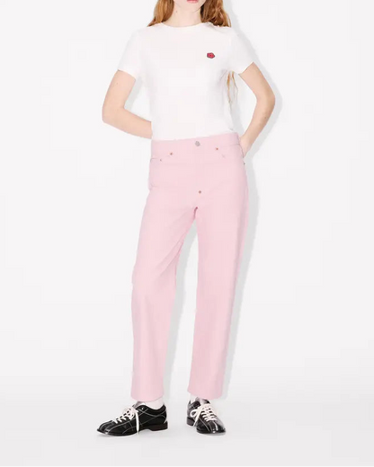 Person wearing a white t-shirt and pink jeans straight leg japanese denim on a white background