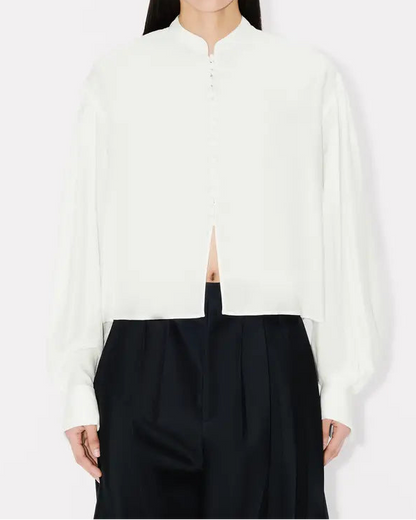 Person wearing a white shirt and black pants on a white background