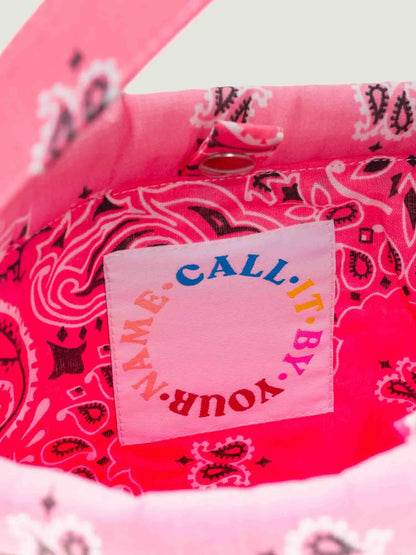 Pink bandana bucket bag with adjustable strap by brand call it by your name, close-up on tag