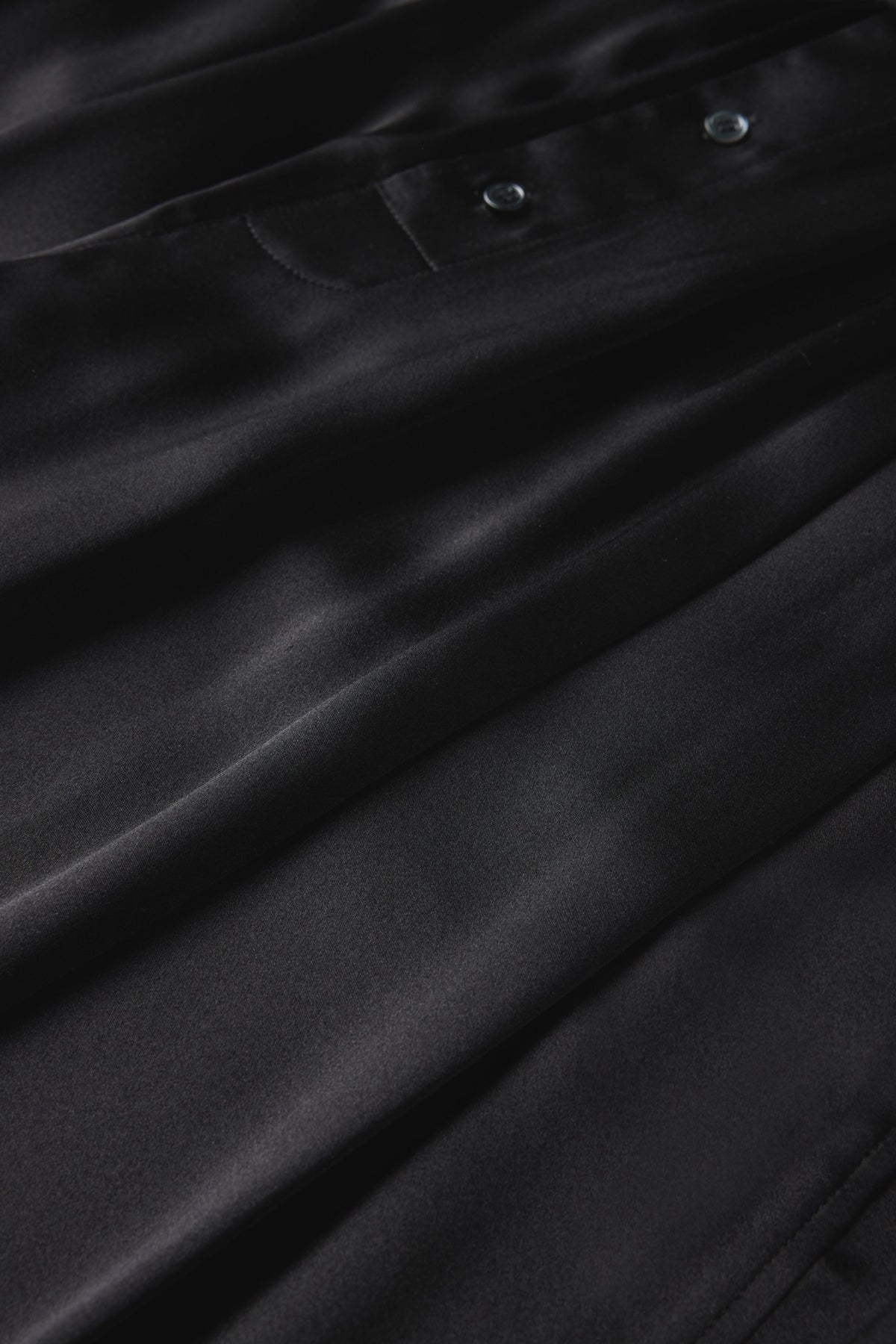 Close-up of the black silk satin and waistband buttons on the Soeur Leopold trousers
