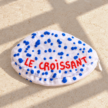 Back of the Brigitte Tanaka Croissant pouch with red Le Croissant lettering and blue dots