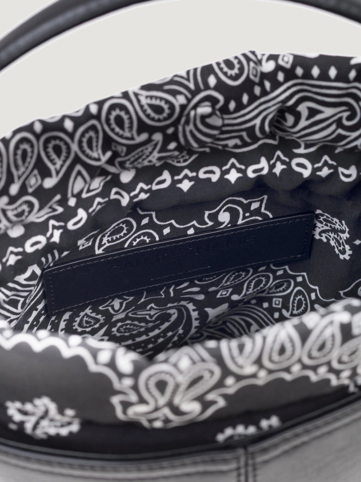 Inside of the Call It By Your Name mini black Peekaboo bag showing the bandana-print lining