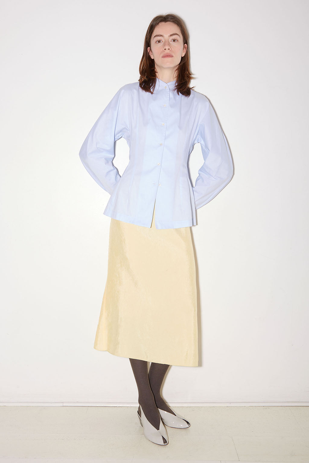 Roseanna Charlene blue poplin shirt styled with a pale yellow skirt, full-length view