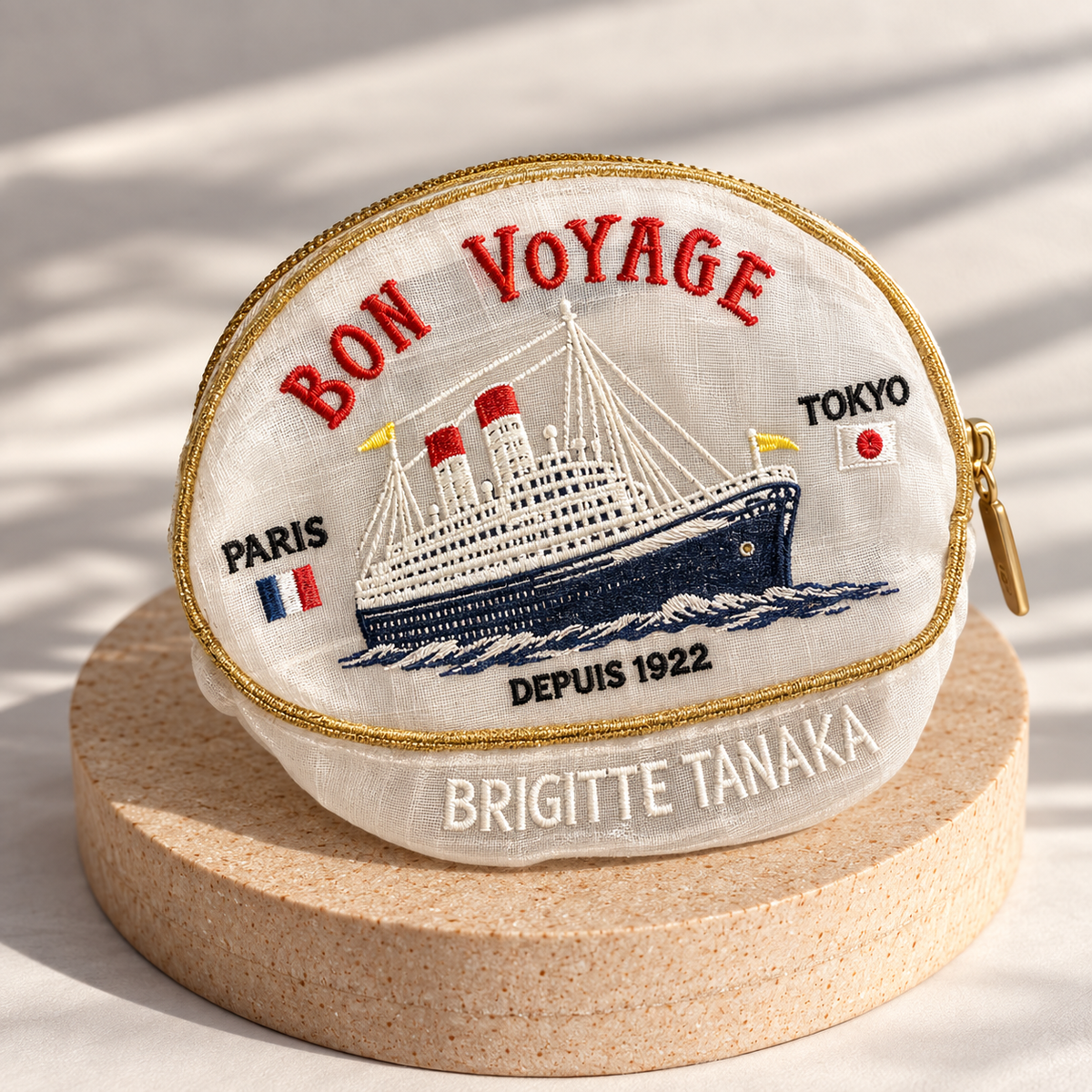Brigitte Tanaka Bon Voyage pouch in white organza with an embroidered ocean liner, on a wooden stand