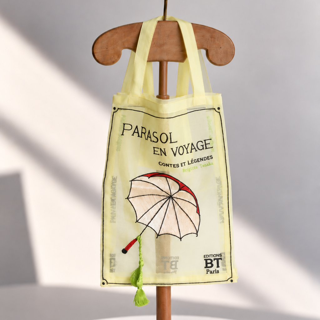 Brigitte Tanaka Parasol Voyage tote in pale yellow organza with an embroidered parasol, on a wooden hanger