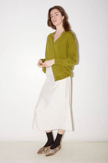Roseanna Lucia moss cardigan styled with a white skirt, full-length view