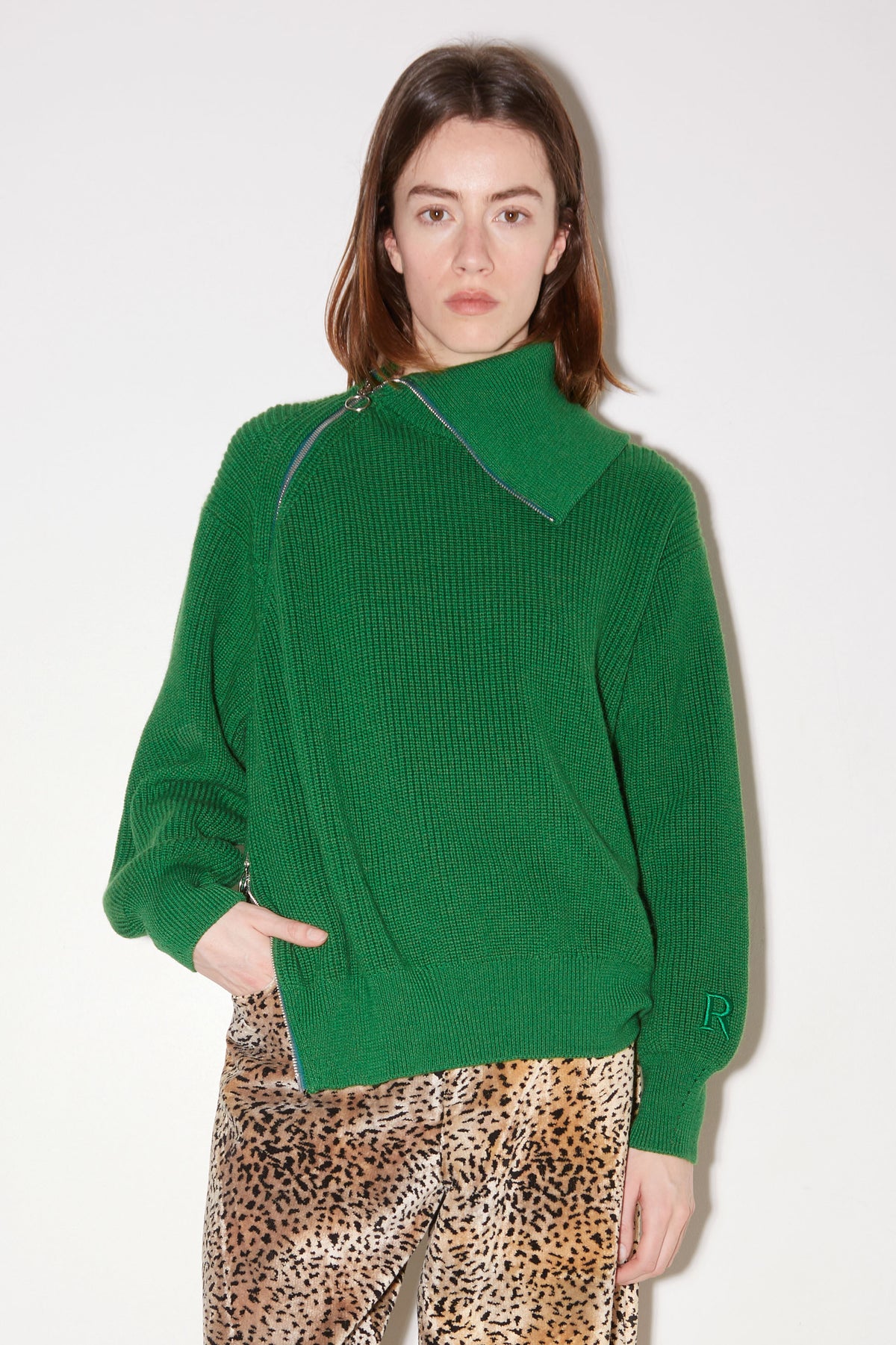 Front view of the Roseanna Zip green pearl-knit sweater with high collar and asymmetric zip