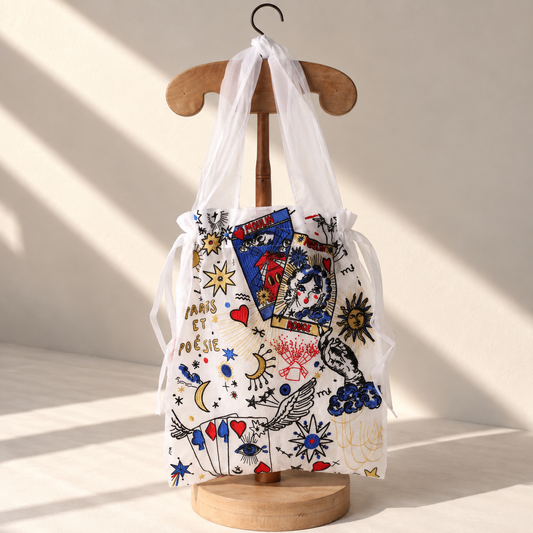 Brigitte Tanaka x Moulin Rouge Divination tote in white organza with tarot card embroidery, on a wooden hanger