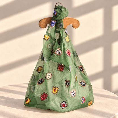 Brigitte Tanaka large double-sided patch tote in green organza with colorful patches, on a wooden hanger