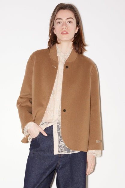 Model wearing the Roseanna Kaia oversized jacket in beige double-faced wool over a lace top with dark jeans